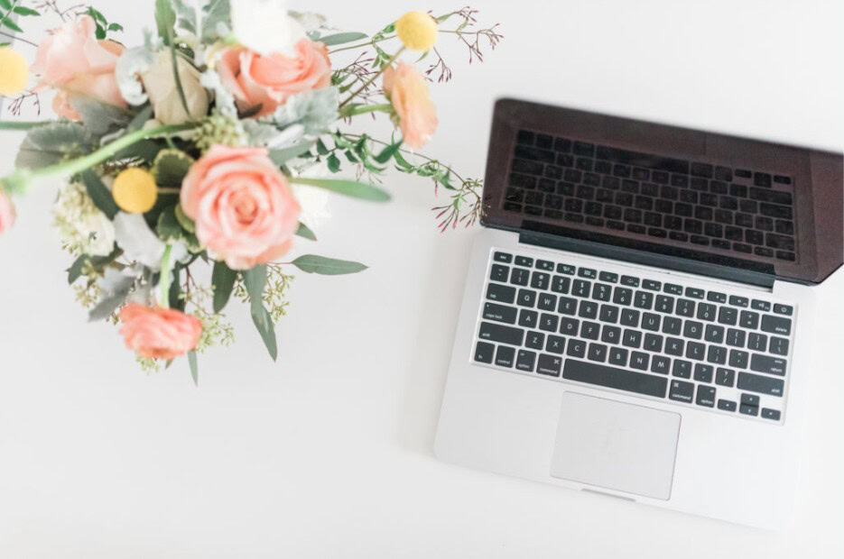 flowers and a laptop on a desk for everyday lifestyle inspiration